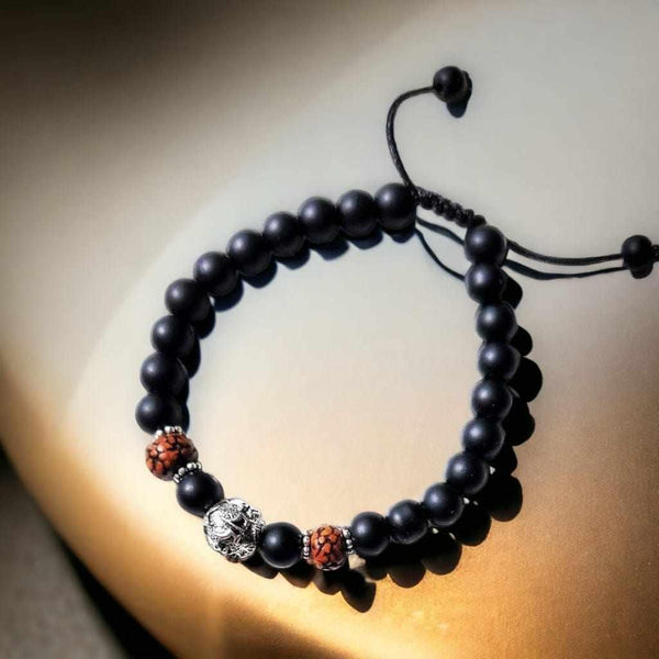 Bracelet bouddhiste en perles noires avec éléphant argenté et perles rouges, symbole de sagesse et méditation