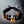 Bracelet bouddhiste avec perles noires, motifs tibétains et pendentif métallique, symbole de méditation et sagesse.