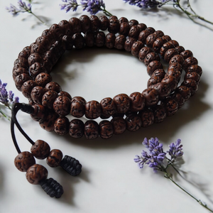 Chapelet bouddhiste en graines de rudraksha avec fleurs de lavande, symbole de méditation et sagesse tibétaine